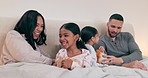 Happy family, fun and playing in a bed with hand, games or comic in their home together. Love, relax and children with parents in a bedroom with weekend freedom, laughing and bonding in their house