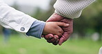 Father, child and holding hands at park for care, love and support outdoor. Closeup, dad and kid together in garden for comfort, connection and family bonding, healthy relationship or trust in nature