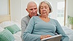 Senior couple on bed with tablet, love or smile checking social media post, meme and relax in home. Digital app, old man and woman in bedroom reading email memory together with kiss, marriage or care