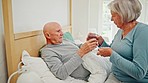 Pills, senior couple and water in a bed with love, care and support with medication and drink. Drugs, vitamin supplements and elderly man with wife together in retirement with marriage and support