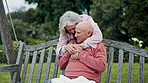Love, hug and old couple on bench in garden, happy morning bonding and relax together in retirement. Marriage, senior man and woman on swing in backyard with embrace, smile and care in conversation.