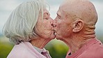 Love, kiss and senior couple in a park happy, free and bonding in nature together. Face, romance and old people in a garden with trust, support and security, smile and fun while enjoying retirement