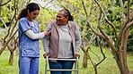 Helping hand, old woman with walker and nurse in garden with support, help or trust at nursing home. Physical therapy, retirement healthcare and elderly person with caregiver walking in park together