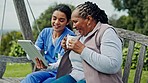 Happy woman, nurse and patient on tablet, bench or swing in relax, entertainment or nature at park. Female person or medical caregiver sitting outdoor with senior, technology or coffee for support