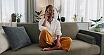 Funny, phone call and black woman in home, talking or communication on sofa. Smartphone, conversation and African person laughing, listening to story and comedy, chat or news and happy in living room