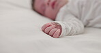 Hand, newborn and sleeping on bed in nursery with relaxing, resting and nap on blanket in morning. Baby, peaceful and dreaming in bedroom of home for child development, growth and nurture or relax