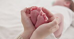 Feet, hands and mother with baby, love and support for care, health and wellness in bedroom. Closeup, family or mama with an infant, protection and child development with bonding or maternity in home