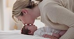 Happy, mother and baby kiss with love, care and support in a home with newborn and bonding. Morning, mom and relax infant with child security and motherhood in a family home on a bed with mama