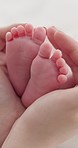 Baby, family and hands with feet on bed for bonding, love and relationship with infant. Adorable, cute and closeup of parent holding toes of newborn for support, wellness and protection at home