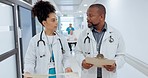 Healthcare, discussion and team of doctors in a hospital with clipboard for information. Conversation, documents and medical workers walking and talking for treatment plan in medicare clinic corridor