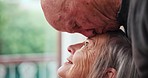 Kiss forehead, love and senior couple by window for bonding, marriage and relationship at home. Retirement, relax and elderly man and woman embrace for commitment, care and trust in living room