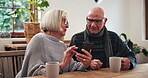 Senior, couple or phone with scroll for social media, reading news article or internet website at table in lounge. Elderly, people and smartphone or laughing for notification or online search at home