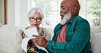 Paperwork, discussion and senior couple in living room talking on debt, mortgage or bill payment. Conversation, documents and elderly interracial man and woman in retirement speak in lounge at home.