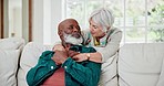 Senior couple, hug and talking on sofa with love, care and support in retirement together with happiness. Old people, relax and smile with embrace in home, living room or conversation in lounge