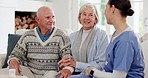 Medical, checkup and a nurse talking to an old couple on a sofa in the living room of their home. Healthcare, appointment or apartment visit with a senior man and woman speaking to a young caregiver