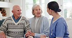 Healthcare, checkup and a nurse talking to an old couple on a sofa in the living room of their home. Medical, appointment or apartment visit with a senior man and woman speaking to a young caregiver