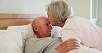 Senior, couple and kiss forehead in bed for support, sick and conversation with retirement or healing. People, man and woman in bedroom with communication, empathy and love for trust, care and rest