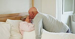 Elderly, couple and kiss forehead in bed for support, sick and conversation with retirement or healing. People, man and woman in bedroom with communication, empathy and love for trust, care and rest