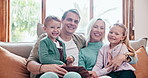 Happy, face and children with parents on a sofa in the living room of modern family home. Smile, bonding and portrait of young kids relaxing with mother and father in the lounge together at house.