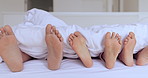 Family, bed and feet with sheet, sleep and together in home with rest, hospitality and comfort with bonding. People, children and bedroom with toes, blanket and sole to relax, holiday or vacation
