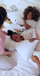 Happy family, bed and pillow fight from above for fun, playing and bonding in their home. Wake up, games or excited children with parents in a bedroom with morning energy, love and freedom in a house