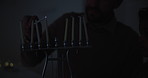 Jewish, culture and a family lighting candles together in their home for Hanukkah celebration. Holiday, religion or tradition with a father and son closeup in the dark for their faith or belief