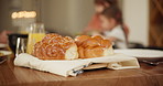 Bread, challah and food on table for shabbat, party or celebration with family in dining room of home. Jewish, tradition and holiday with people, meal and eating in lounge for bonding and sabbath