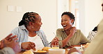 Black family, senior mother and woman at dinner in home, comic joke and laugh with memory, love and care. Men, women and kids in conversation, chat or food in house, connection or thanksgiving brunch