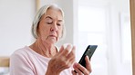 Old woman, reading and phone by internet in home for research of medication. Elderly person, looking and bottle of pills for information with technology, cellular or network in bedroom for health