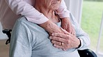 Love, support and couple holding hands in wheelchair by window for thinking in living room at home. Comfort, compassion and closeup of elderly man with disability and woman in retirement at house.