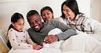 Parents, girl children and bed with phone, smile and games with interracial love, care and bonding in house. Father, mother and daughter kids in bedroom, relax and smartphone for video at family home