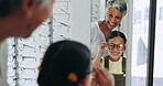 Woman, child and mirror for eyeglasses, shop and smile for eyesight and glasses. Eyewear shopping, retail and grandparent for spectacles, buying and happiness for girl, store and lens for eyecare