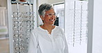 Glasses, shopping and senior woman smile with check and optometrist with eye test. Decision, customer and store with prescription eyewear and lens with frame choice and smile at a retail shop