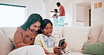 Happy, cellphone and child with mother on a sofa networking on social media in the living room of family home. Bonding, relax and girl kid scroll on a phone with Asian mom in the lounge of house.