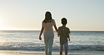 Back, beach or holding hands with a mother and son on the sand by the ocean at sunset together. Family, love or vacation with a woman parent and boy child outdoor on the coast for summer holiday