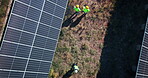 Drone of solar panels, engineering people and farm with renewable energy teamwork, electricity or eco friendly power. Aerial view of agriculture, photovoltaic grid and group walking on land or field