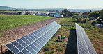 Drone, engineering and people with solar panels outdoor for renewable energy, clean electricity or sustainability. Aerial view, workers and photovoltaic in a farm or nature for maintenance or work
 
