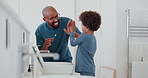 Child, learning and brushing teeth with dad in bathroom with high five for self care in family home. Teaching, grooming or father with kid in dental routine with toothpaste, toothbrush or oral health