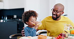 Father, child or communication with orange juice by table, for lunch or nutrition with happiness in family home. African, dad or son with sip drink, vitamin c or fruit for health wellness at dinner