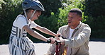 Family, father and daughter with bicycle for teaching in ride in street, outdoors or neighborhood. Man, girl or bonding for quality, time or together in childhood for encouragement, helmet and safety
