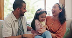 Family, love and parents tickling their daughter on a sofa in the living room of their home together. Smile, energy or fun with a mother, father and girl child playing in their apartment for bonding