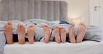 Sleeping, feet and family wake up in a bed with morning energy, movement or bond in their home together. Barefoot, love and kids with parents in a bedroom after sleep, nap or resting on vacation