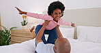 Black family, father and a daughter flying on the bed in their home together for playing or bonding. Smile, fantasy plane and a man parent having fun with his girl child in the apartment bedroom