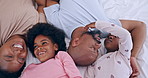Happy, relaxing and black family having fun in bed together at modern home for bonding. Smile, love and African mother and father playing and resting with young kids in the bedroom of house.