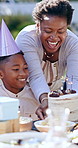Child, happy birthday and singing in outdoor celebration, party and cake or candles at park. Black family, happiness and support for son, cheers and event or together, garden and food or presents
