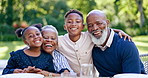 Happy, nature and grandparents with children at a picnic for family time and bonding in a garden. Smile, portrait and African senior man and woman in retirement embracing kids in the park together.