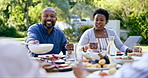 Family, lunch outdoor and eating in garden with drink, food and relax with conversation for thanksgiving. Black woman, African man and giving bowl for salad, meat and care at event, party or brunch