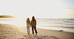 Beach, walking and mother holding hands with kid at sunset on travel vacation, holiday or weekend trip. Happy, love and young mom bonding with girl child on sand by ocean or sea on tropical getaway.