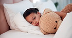 Healthcare, sick child in bed with teddy bear with cold or flu in home, sad and tired with rest. Illness, fever and face of girl in bedroom with fluffy toy for comfort, recovery and pediatric care.