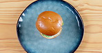 Person, hand and burger in Timelapse for delicious meal, snack or lunch above on wooden table. Top view or closeup of hungry customer or hamburger creation for fast food, eating or mockup space